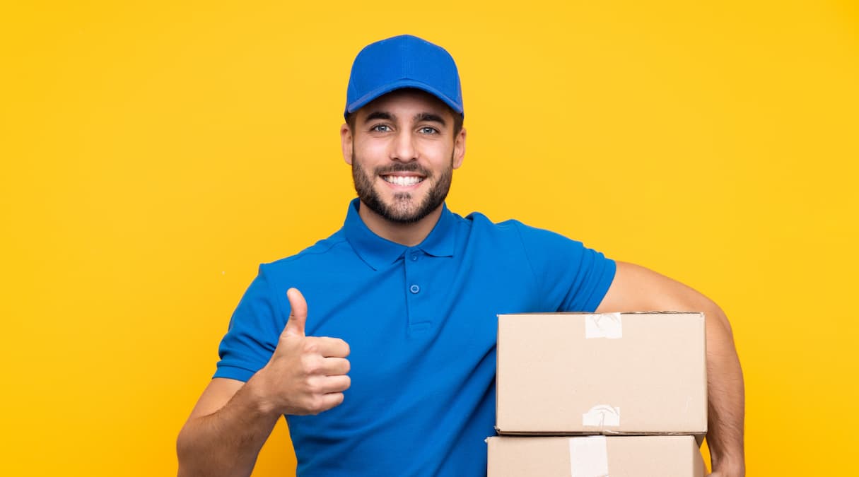 Entregador dos Correios carregando encomendas em caixas de papelão, compradas com a funcionalidade de correios barato da Frenet||