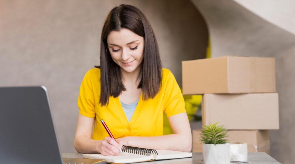 Mulher lojista assistindo vídeo aula sobre logística para lojas virtuais||