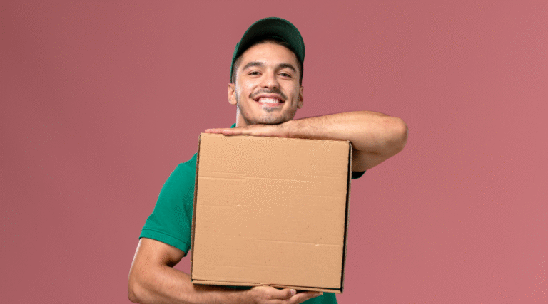 Entregador sorrindo e segurando uma caixa de entrega com as duas mãos